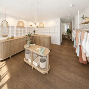 Interior de tienda de ropa con mobiliario de madera, iluminación colgante y expositores de prendas