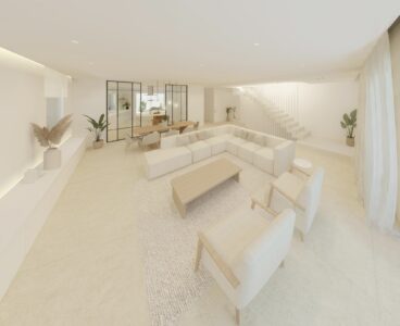 Salón-comedor de vivienda contemporánea con distribución abierta, mobiliario claro y escalera interior
